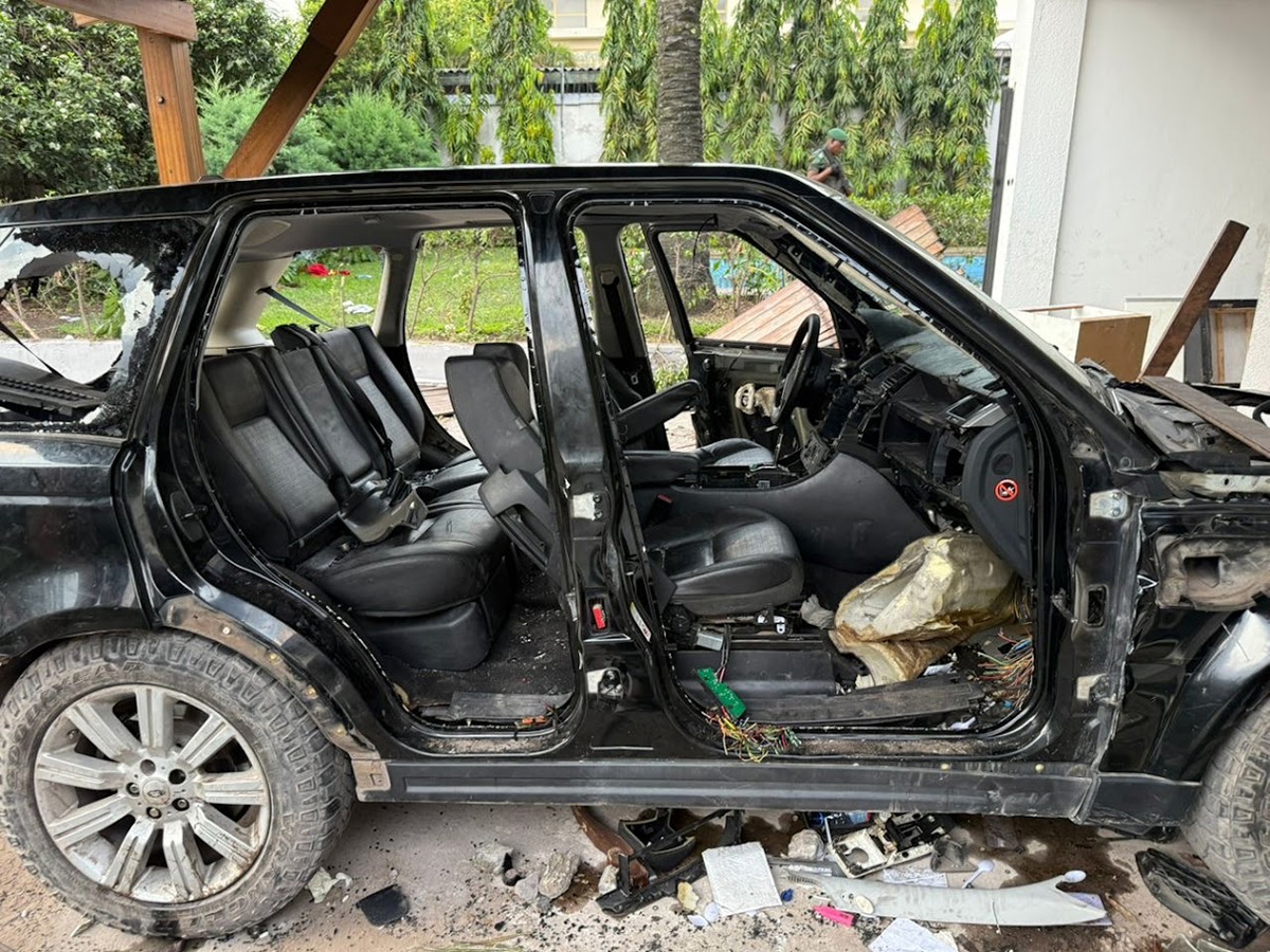 Heavily damaged black SUV with shattered windows and missing doors after an attack on the author’s residence.