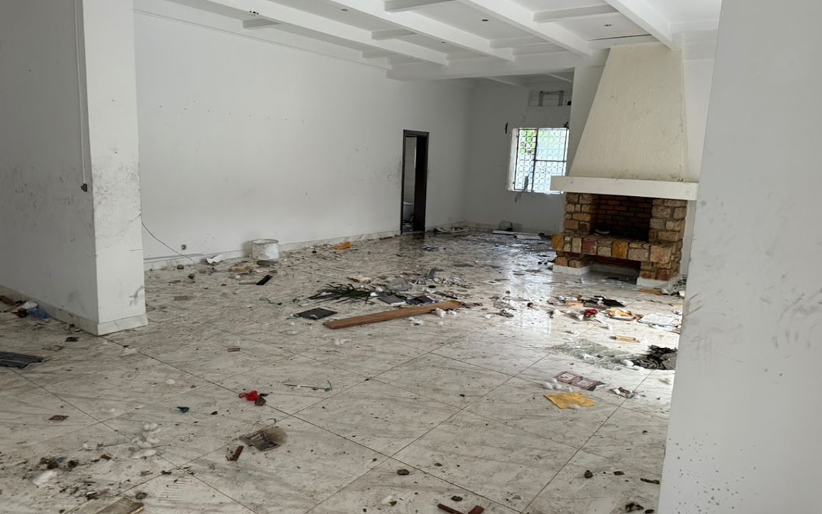 Empty, ransacked room littered with debris after looters removed the contents of the house.
