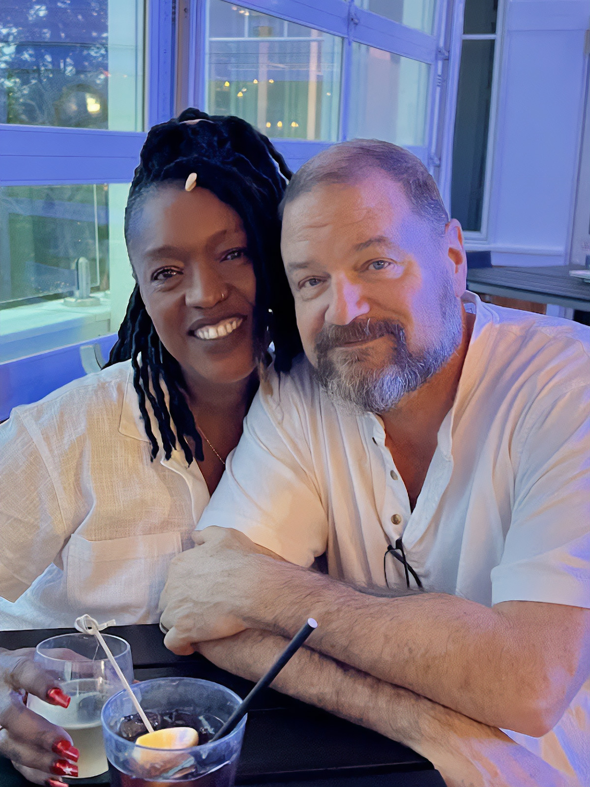 The author and his spouse, Angelique, smile together while seated at a table.